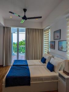 a bedroom with a large bed with a ceiling fan at Oceanfront condo 3-2-01- Nilaveli in Nilaveli +25 photos