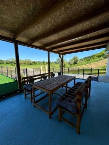 a picnic table with benches and a view of a field at Vikendica Mavi in Gradačac