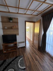 a living room with a flat screen tv and a door at Vikendica Mavi in Gradačac