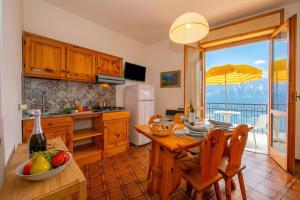 a kitchen with a table and a dining room at Appartamenti Secrel in Tremosine Sul Garda
