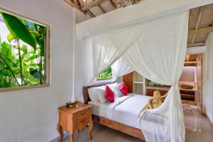a bedroom with a white bed with a canopy at Villa Olala Penida in Nusa Penida