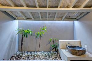 a bathroom with a stone sink and two plants at Villa Olala Penida in Nusa Penida +81 photos