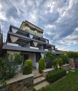 a building with bushes in front of it at Apartments and Villas Janev in Star Dojran