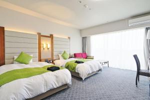 two beds in a hotel room with green and white at Satsuma Resort Hotel in Satsuma +39 photos