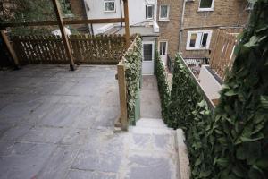 a balcony with a wooden railing and a fence at Deaf Property - Woolwich Elizabeth Line Studios in Woolwich