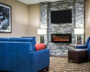 a lobby with two blue chairs and a fireplace at Comfort Inn Morris I-80 in Morris