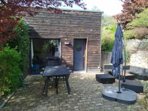 a small wooden shed with a table and an umbrella at Chalet cosy en centre-ville in Le Puy-en-Velay