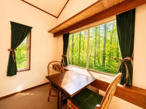 a dining room with a table and a large window at Komorebi Myoko Lodge in Myoko +18 photos