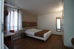 um quarto com uma cama, uma secretária e uma janela em Fasthotel Tours Sud em Chambray-lès-Tours