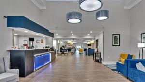 an empty lobby with blue chairs and a counter at Comfort Suites Salisbury I-85 in Salisbury
