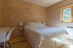 a bedroom with a bed and a desk and a window at Le grand tétras in Boutx
