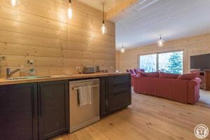 a kitchen and living room with a red couch at Le grand tétras in Boutx