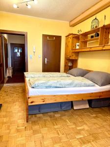 a large bed in a room with a wooden frame at Alpenhof M&E in Bad Kleinkirchheim