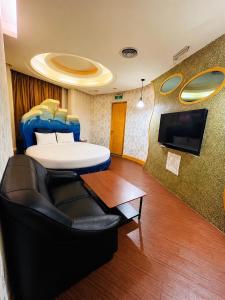 a room with a bed and a couch and a table at Walker Motel 2 in Taipei