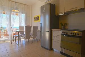 a kitchen with a stainless steel refrigerator and a table at Into The Blue in Agia Paraskevi