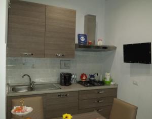 uma pequena cozinha com um lavatório e um fogão em B&B Villa Angelica em Mili Marina