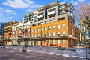 a large brick building on a city street at Terminus Apartment Hotel, an Ascend Collection Hotel in Newcastle