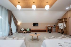 a living room with two beds and a table at Plerntaan HoReCa in Ban Khlong Kum