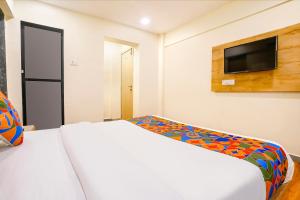 a bedroom with a white bed and a flat screen tv at Via 24x7 in Mumbai