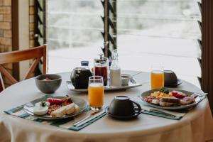 a table with plates of breakfast food and orange juice at Riverside Rest Nambucca Heads in Nambucca Heads