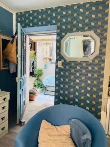 a room with a blue couch and a mirror at La Vannière in Le Poujol-sur-Orb