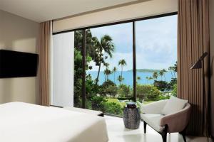a bedroom with a bed and a chair and a large window at Hyatt Regency Koh Samui in Chaweng