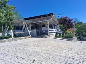 a house with a pavilion next to a cobblestone driveway at Casutele Verzi Camera King in Ocnele Mari