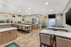 a restaurant with tables and chairs and a kitchen at Quality Inn JFK Airport Rockaway Blvd in Queens