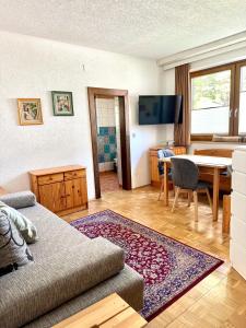 a living room with a couch and a table at Alpenhof M&E in Bad Kleinkirchheim