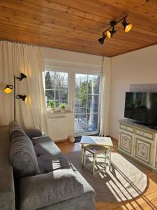 a living room with a couch and a flat screen tv at Kiek mol rin - Richmanns Appartements in Hüde
