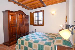 a bedroom with a bed and a wooden cabinet at Agriturismo Cameli in Certaldo