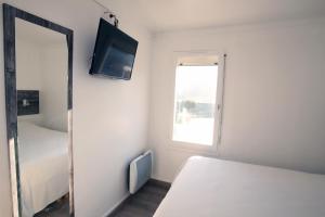 1 dormitorio con espejo, 1 cama y TV en Fasthotel Albertville en Albertville