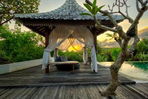 a gazebo on a deck next to a pool at Villa Olala Penida in Nusa Penida