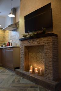 a living room with a fireplace with candles and a flat screen tv at Apartment Zebra in Estosadok