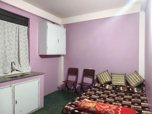 a room with two beds and a kitchen with chairs at itynnad homestay in Shillong +15 photos