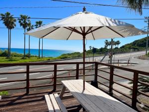 a picnic table with an umbrella on the side of a road at Guest House Goofy in Hyuga