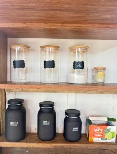 a shelf with jars and other kitchen items on it at Chalé amanhecer in Cobras