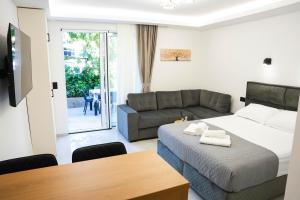 a bedroom with a bed and a couch and a table at Stevovic Apartments - Brand New Apartments in Tivat
