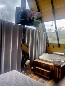 a bedroom with a tub and a tv on the wall at Chalé amanhecer in Cobras