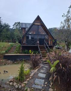 a house with a staircase leading up to it at Chalé amanhecer in Cobras