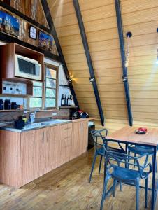 a kitchen with wooden cabinets and a table and chairs at Chalé amanhecer in Cobras