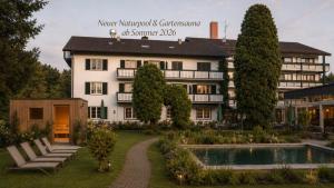 a hotel with a pool in front of a building at Garden Hotel Reinhart in Prien am Chiemsee
