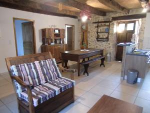 ein Wohnzimmer mit Sofa und Klavier in der Unterkunft Gîte à la ferme in Pachins
