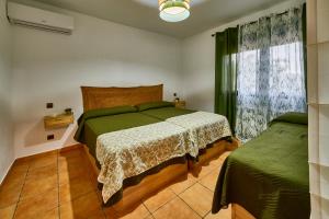 a bedroom with a green bed and a window at FINCA VALDELAJARA a 20 minutos de Puy du Fou in Toledo