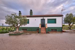a white and green building with a tree in front of it at FINCA VALDELAJARA a 20 minutos de Puy du Fou in Toledo