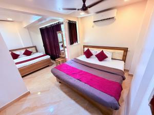a bedroom with two beds with red pillows at Hotel Kings Residency Panvel in Navi Mumbai