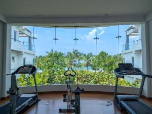 a gym with three treadmills in front of a large window at Oceanfront condo 3-2-01- Nilaveli in Nilaveli