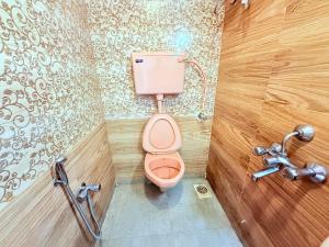 a bathroom with a pink toilet in a stall at Hotel Kings Residency Panvel in Navi Mumbai +74 photos