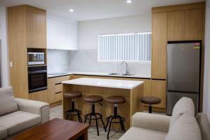 a kitchen with a counter and stools in it at Taisia & Liku Homes in Nuku‘alofa