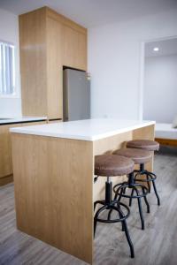 a kitchen with a counter with bar stools at Taisia & Liku Homes in Nuku‘alofa